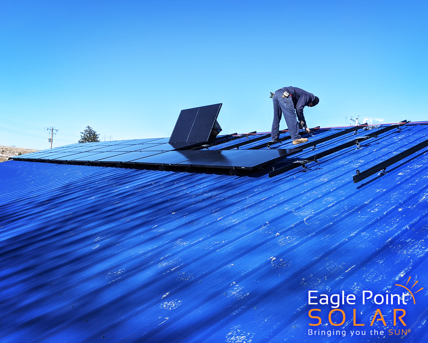 technician installing solar panels on roof