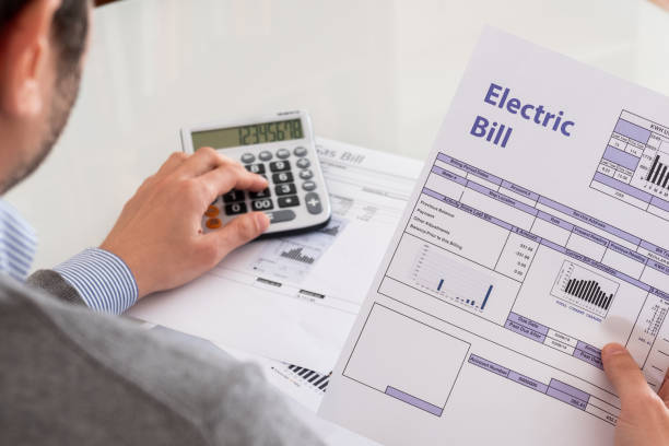 Man with an electric bill and a calculator
