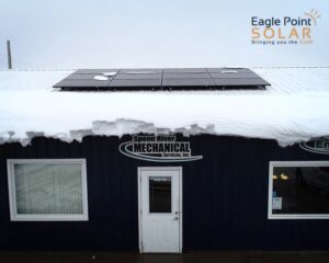 Solar panels atop a mostly snow-covered roof