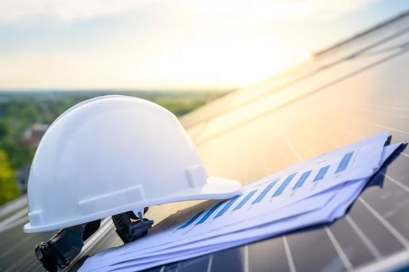 A hard hat and a solar report sitting on top of a solar panel